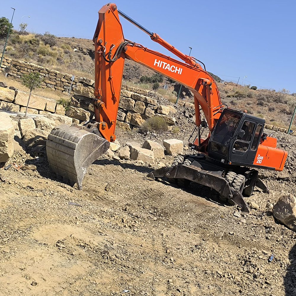 Excavadora Hitachi realizando movimientos de tierra en Málaga - MURES Excavaciones