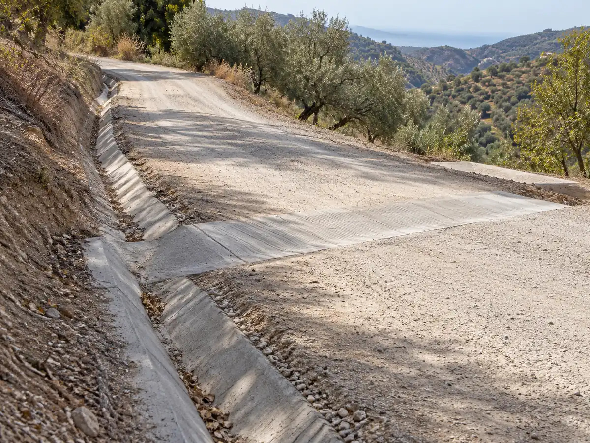 Cuneta y badén de hormigón para evacuar el agua de un camino rural