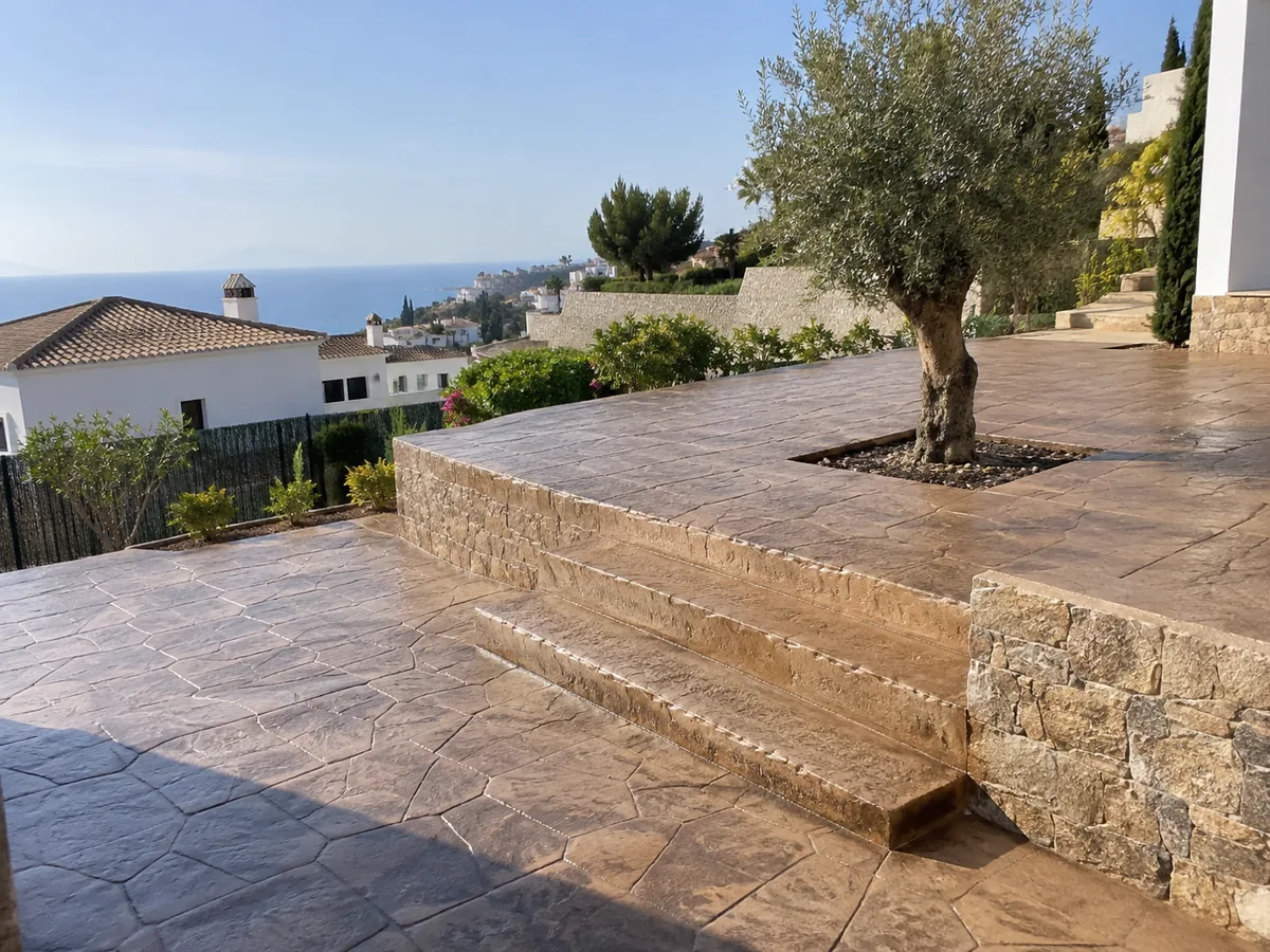 Terraza de hormigón impreso en una urbanización en pendiente de Rincón de la Victoria