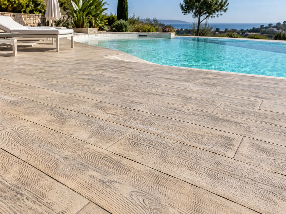 Hormigón impreso imitación tarima de madera color arena en playa de piscina
