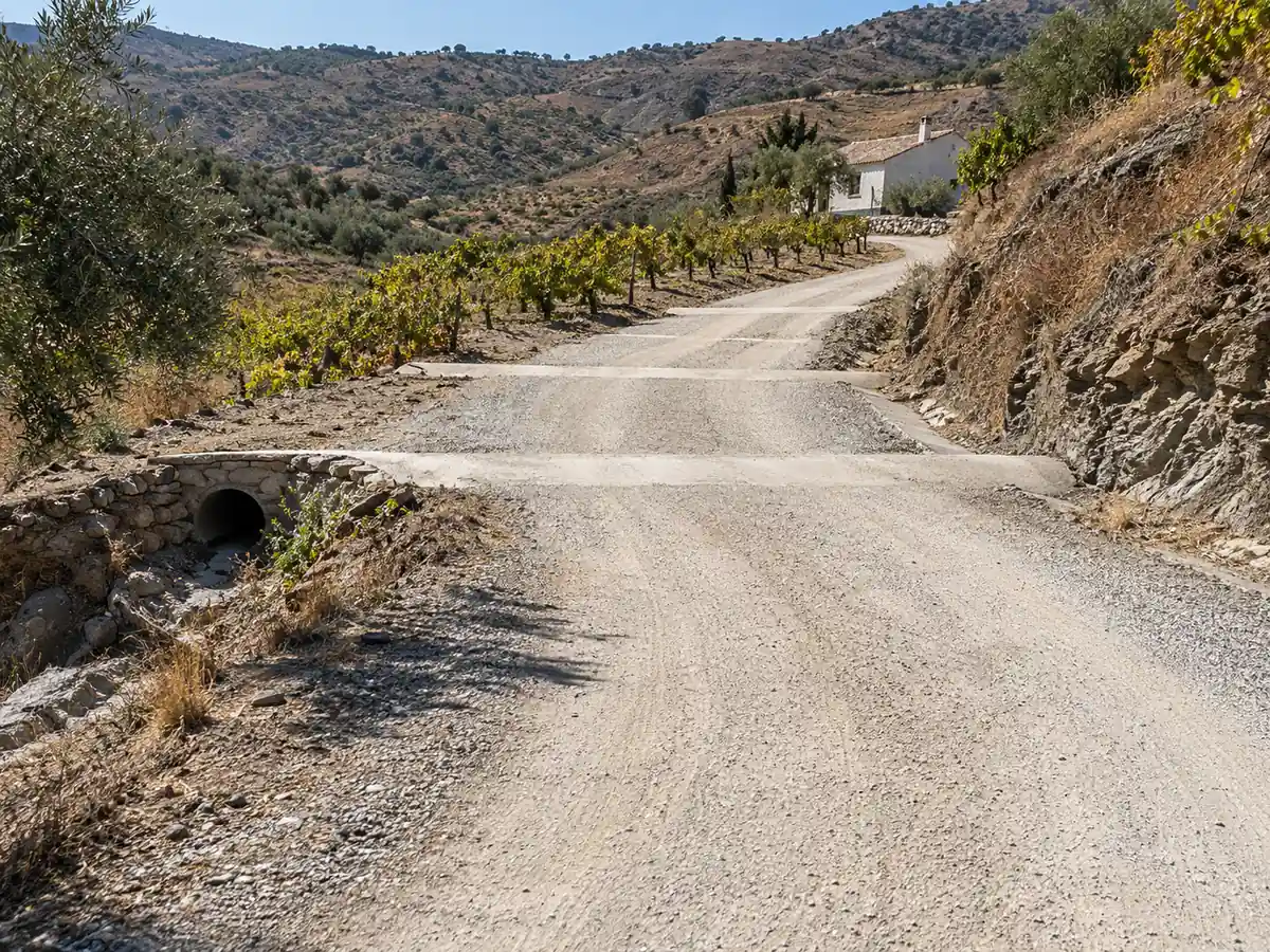 Camino de acceso con zahorra y badenes en una casa de Moclinejo