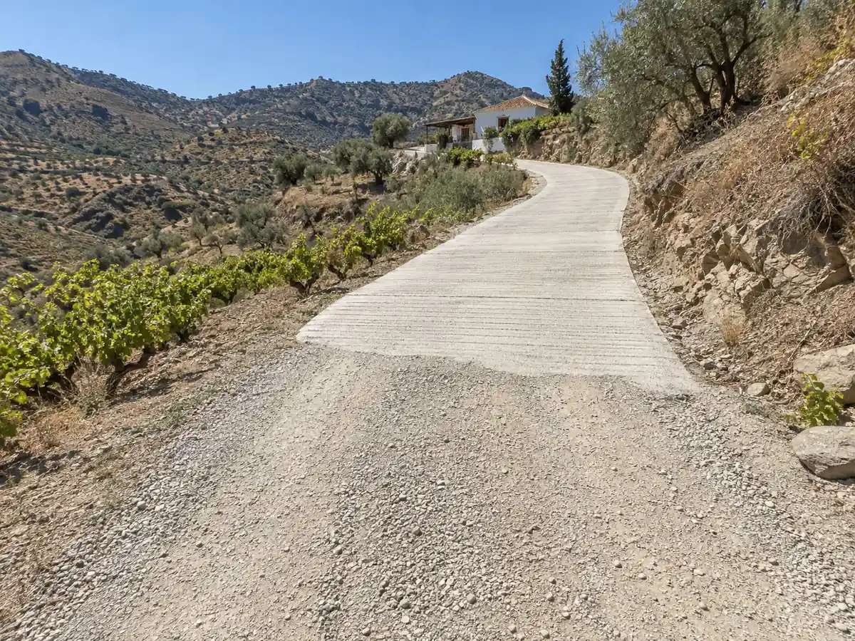 Carril de montaña con tramos hormigonados hasta un cortijo de Comares