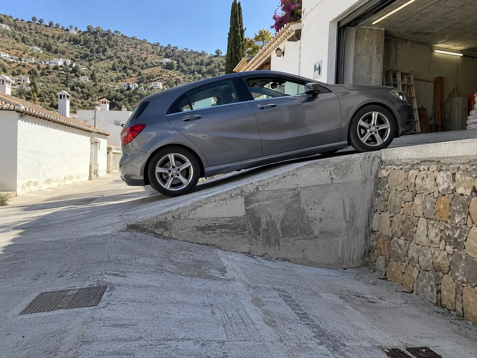 Rampas de hormigón y entradas de coches 24 Coche bajando una rampa de garaje con cambio de pendiente brusco